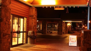 An outdoor pizza restaurant with stone walls and a covered seating area. - The Station (Jindabyne)