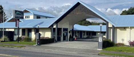 A building with a blue roof and a sign indicating it is a motor lodge.