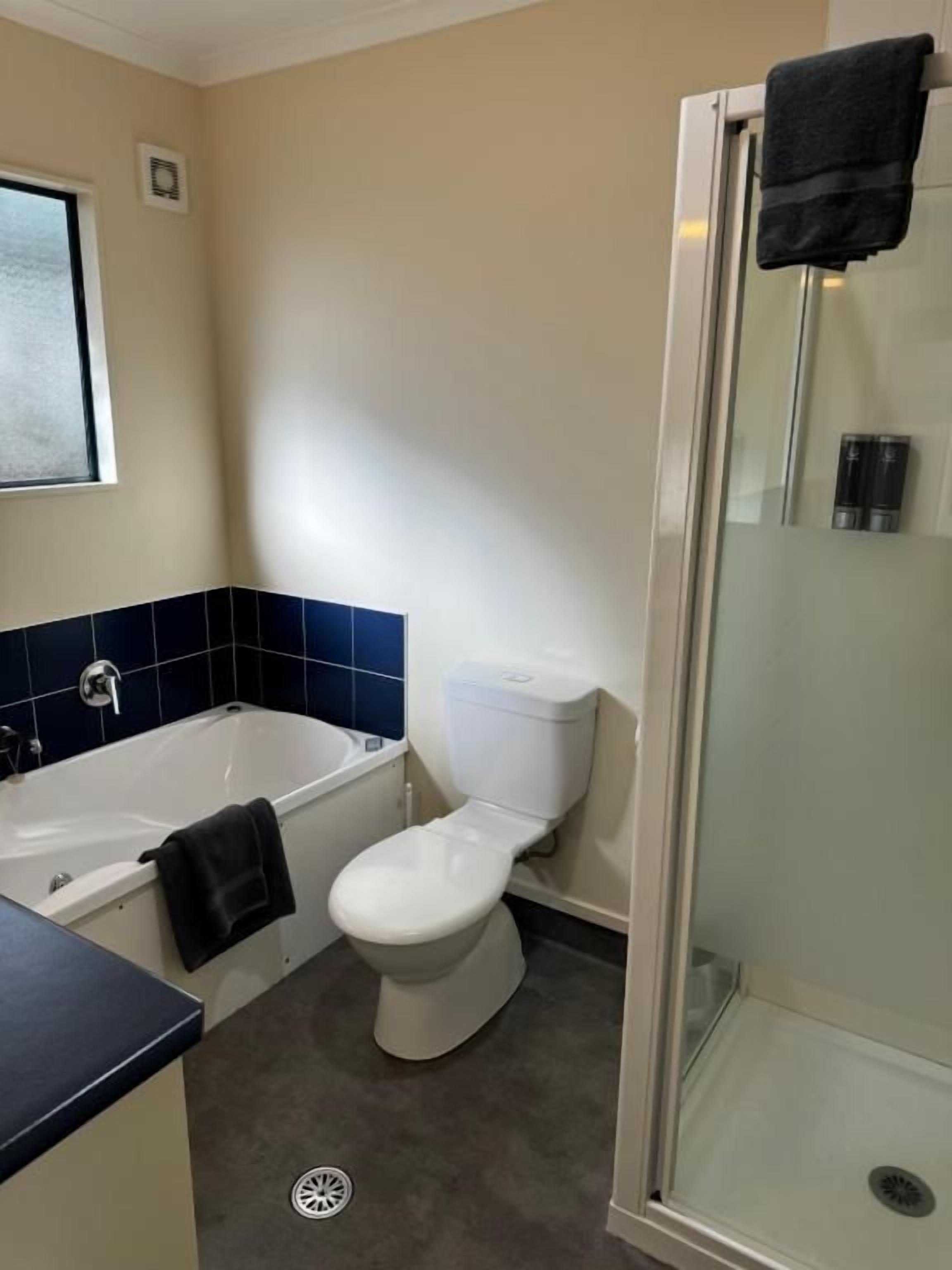 Ein Badezimmer mit Badewanne, Toilette und einer Duschkabine.