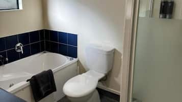 Ein Badezimmer mit Badewanne, Toilette und einer Duschkabine.