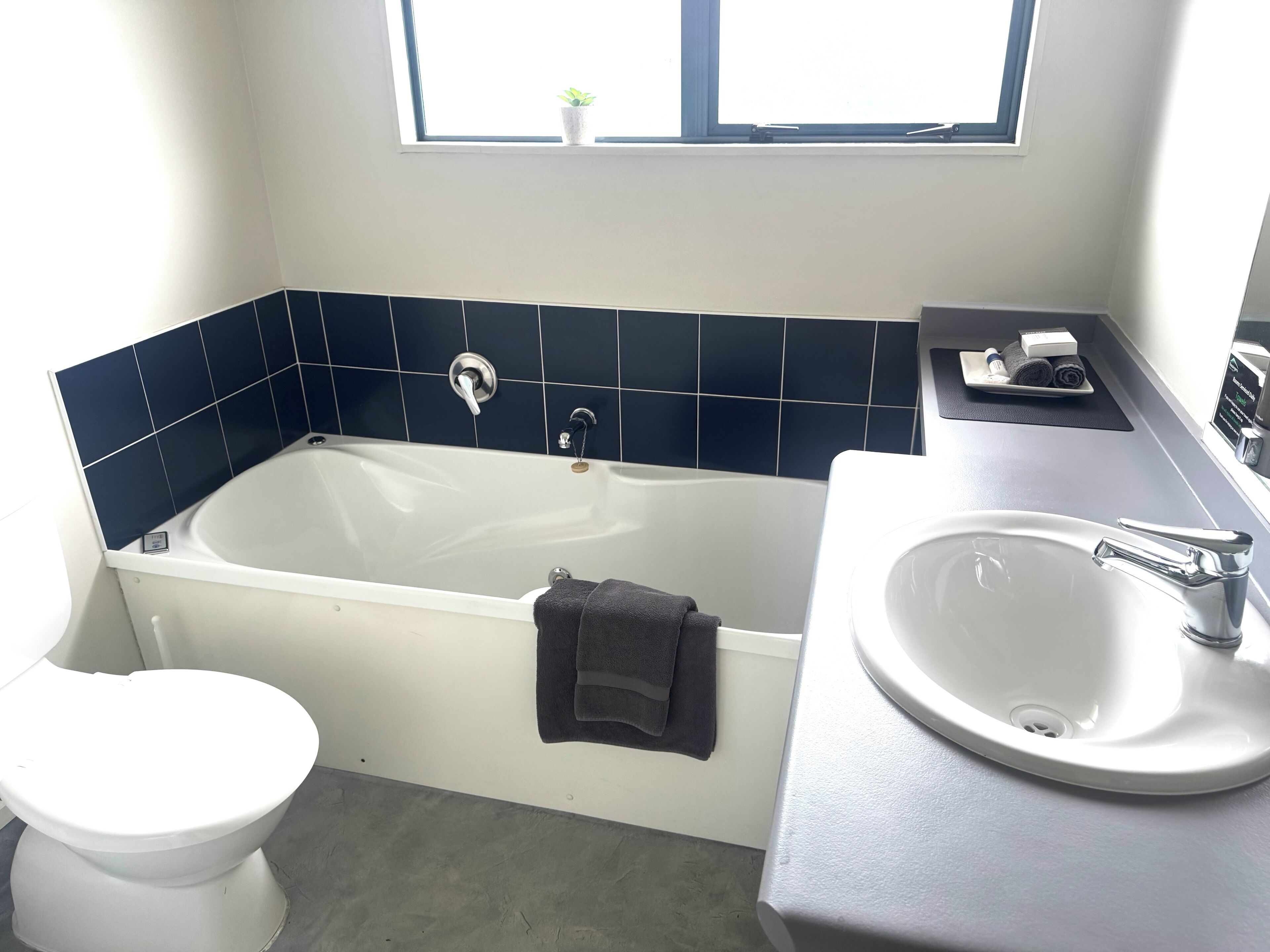 A bathroom with a bathtub, toilet, and sink.