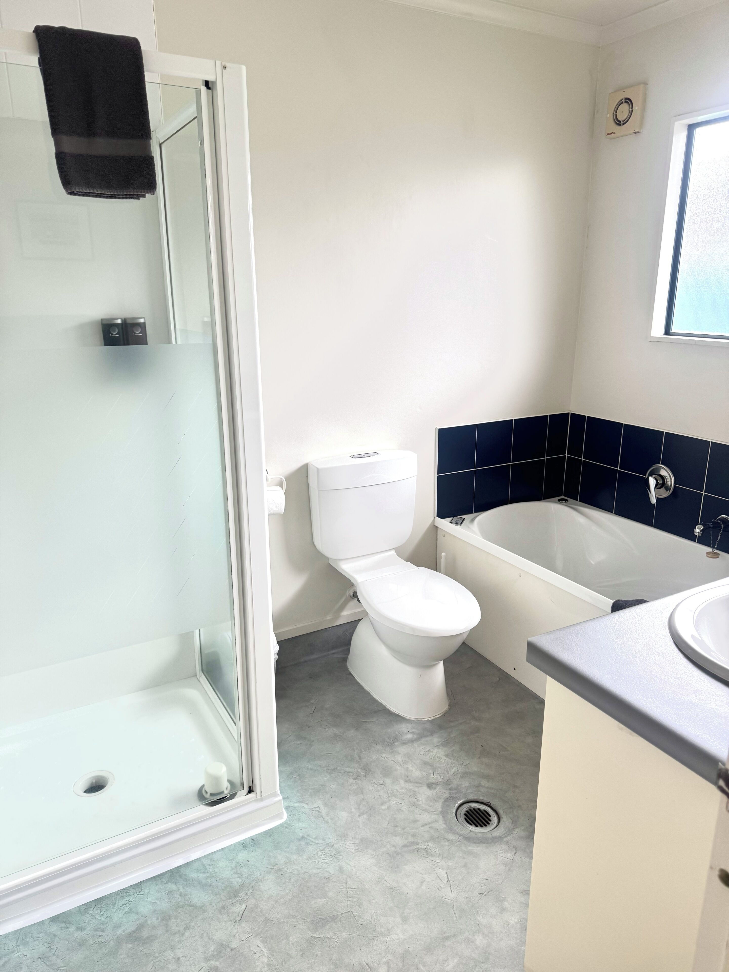 A bathroom with a glass-enclosed shower, a white toilet, a bathtub, and a sink.