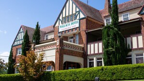 Ein großes, historisches Hotel mit einem markanten Schild, auf dem "Wallacia Hotel Gegründet 1930" steht.