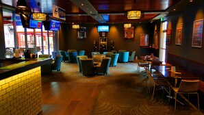 Ein Restaurantinneres mit Barbereich, Sitzgelegenheiten und einem Fernseher.