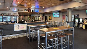 A restaurant with a bar area, multiple tables, and chairs. - Hervey Bay Hotel & Resort (Pialba)