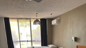A hotel room with two beds, a desk, and a view of the outdoors. - Hervey Bay Hotel & Resort (Pialba)