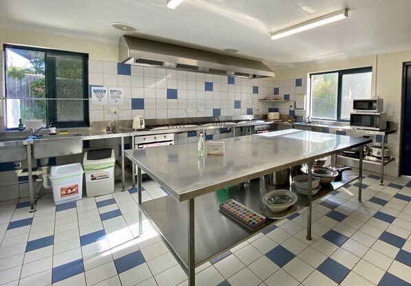 A kitchen with a large island, stainless steel appliances, and a tiled backsplash.
