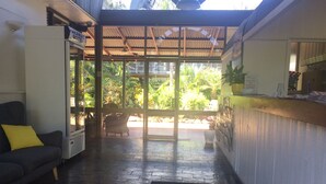 Un espace d’accueil avec un canapé, une petite table et un panneau indiquant un motel.