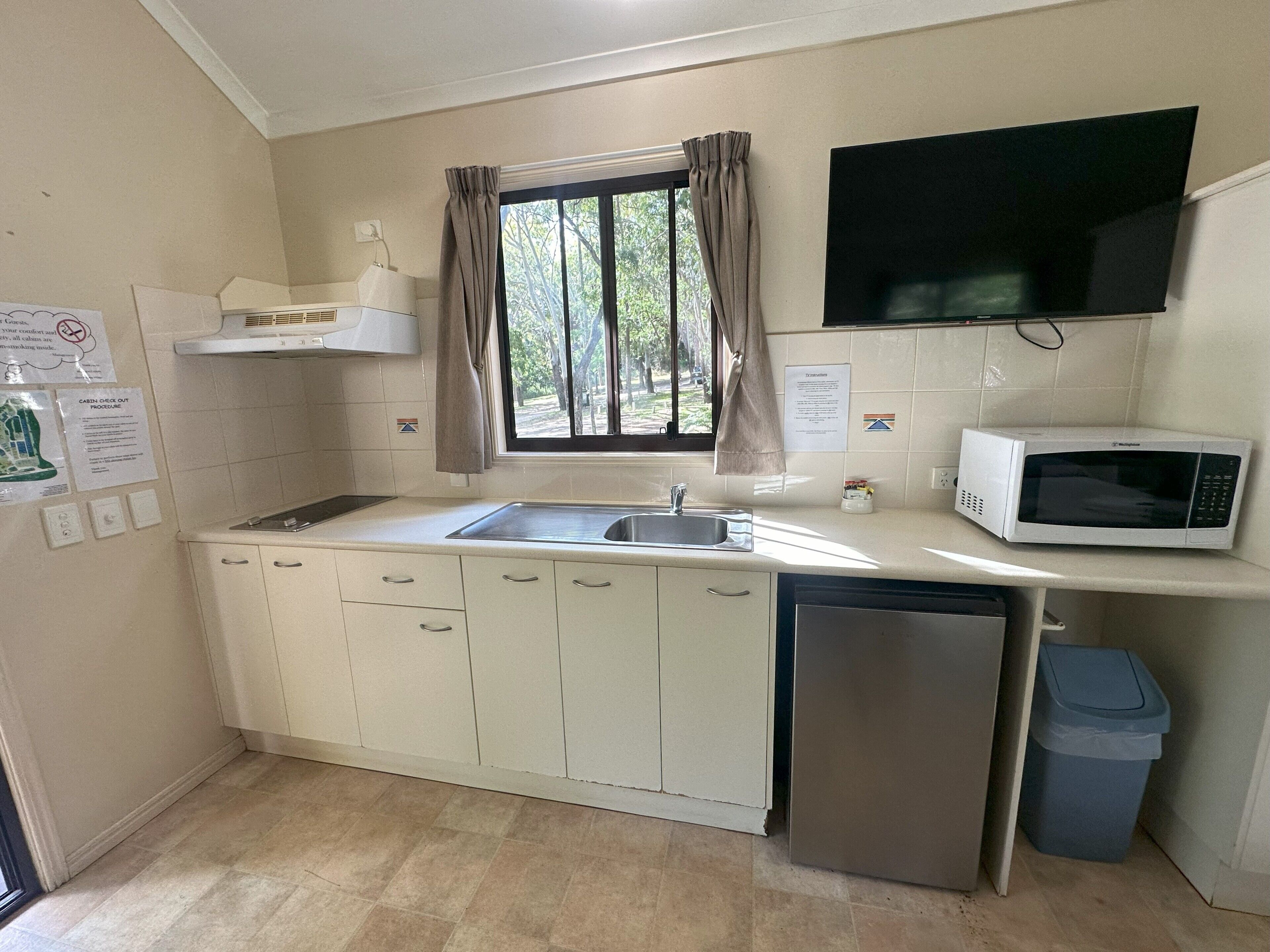 A compact kitchen with a sink, microwave, and dishwasher.