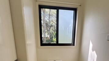 A small, clean bathroom with a toilet, bidet, and a window.