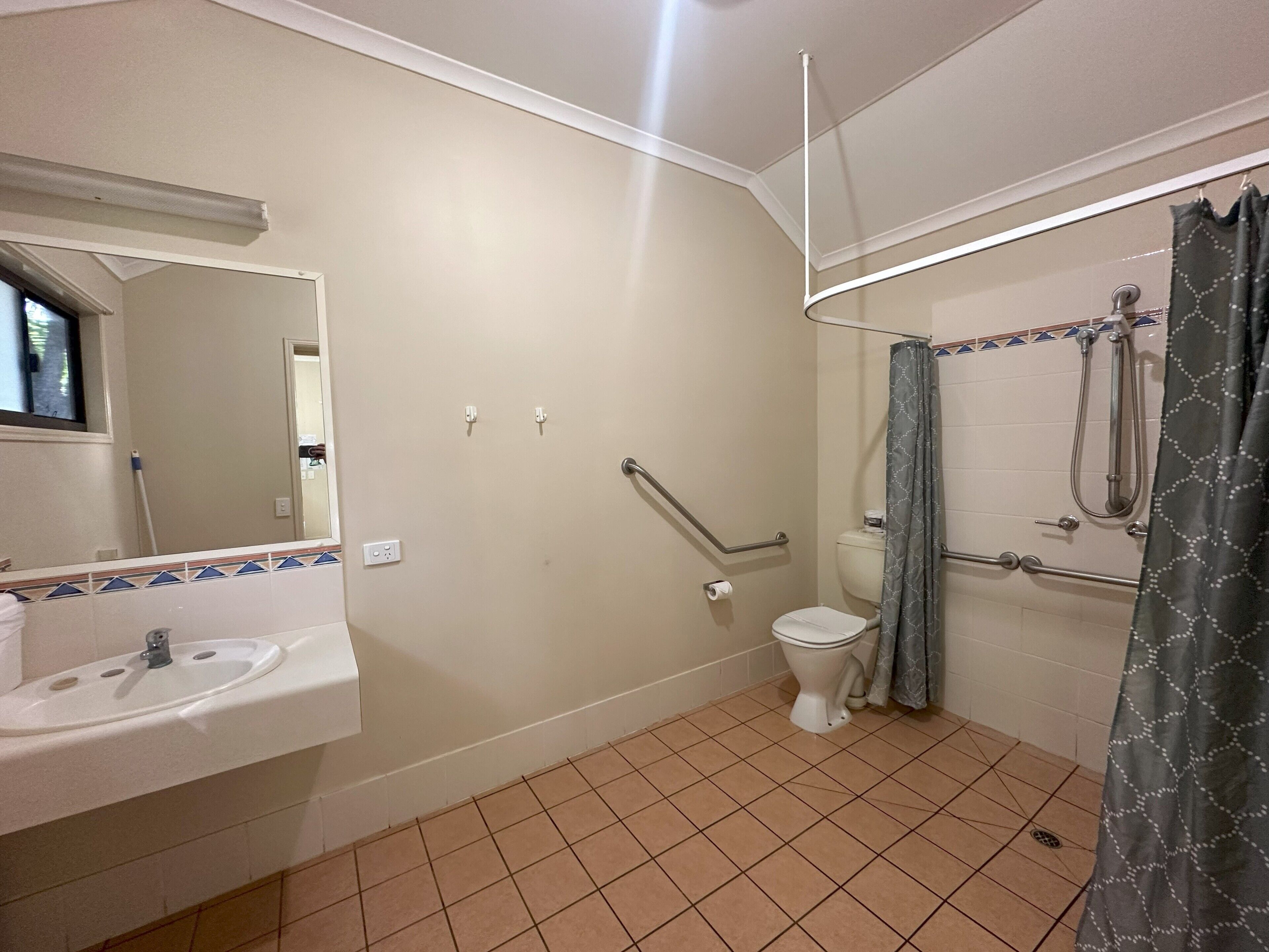 A bathroom with a sink, toilet, and shower area.