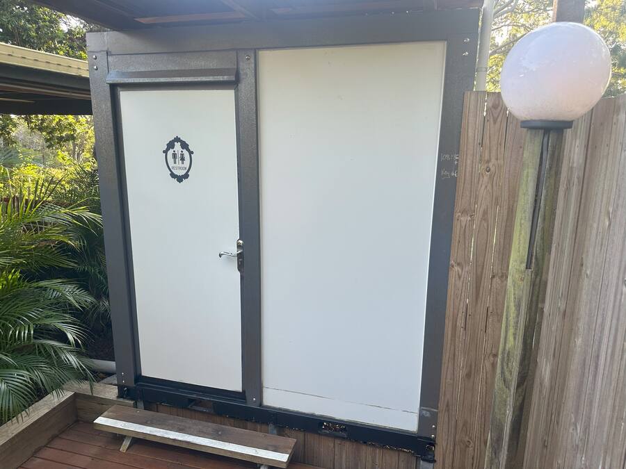 A two-door structure with a 'Restroom' sign on the left door.