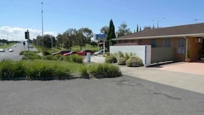 A building with a flat roof and a paved driveway. - Rippleside Park Motor Inn (Drumcondra)