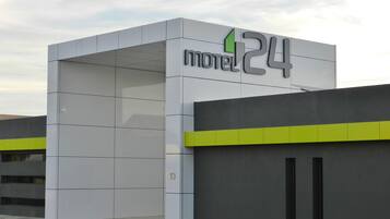 Een modern motelgebouw met een opvallend bord waarop 'motel 24' staat.