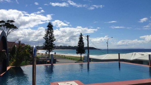 Ein Pool mit Blick auf den Ozean und einen klaren Himmel.