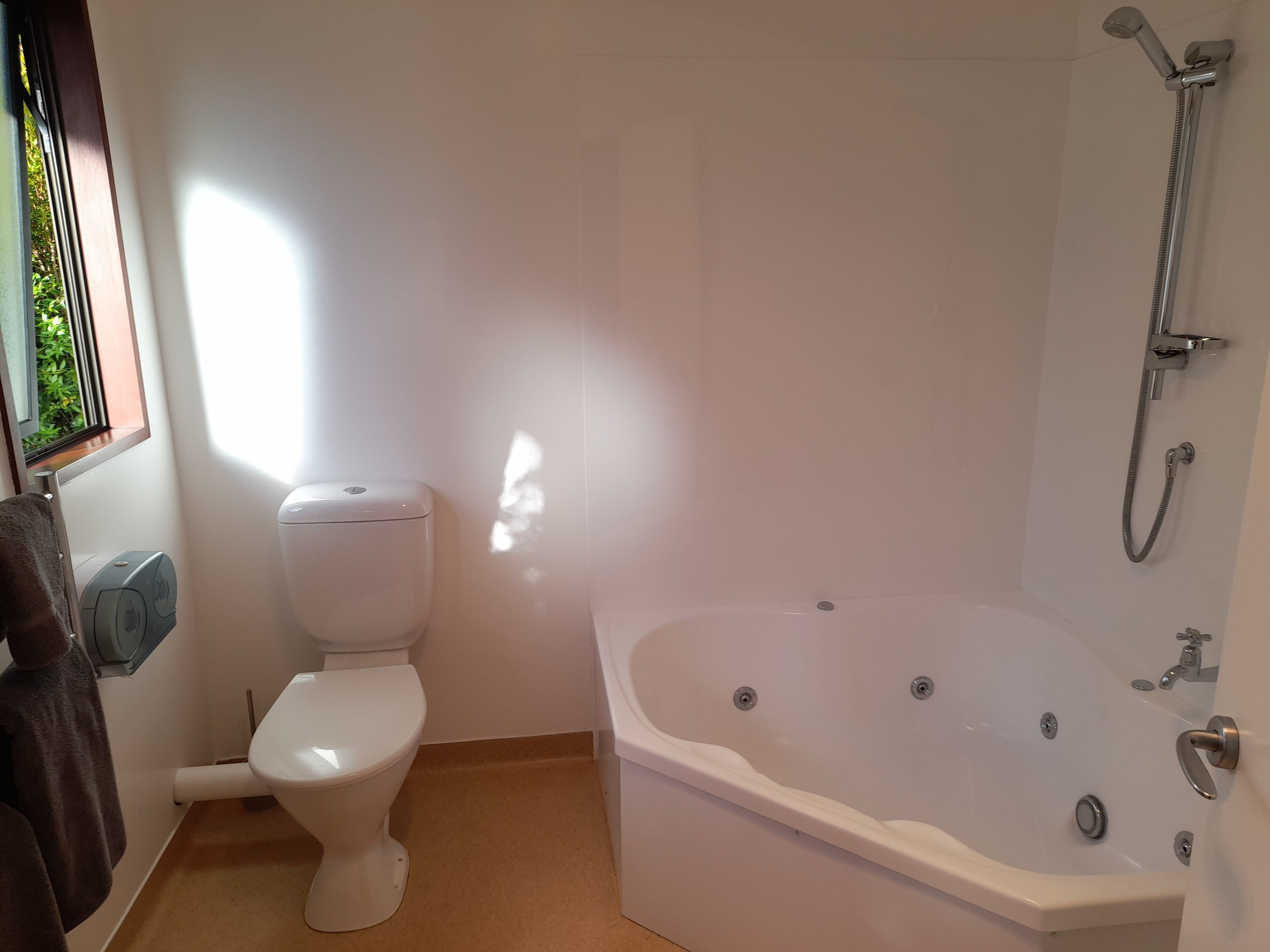 A bathroom with a toilet, a bathtub, and a shower.