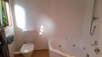 A bathroom with a toilet, a bathtub, and a shower.