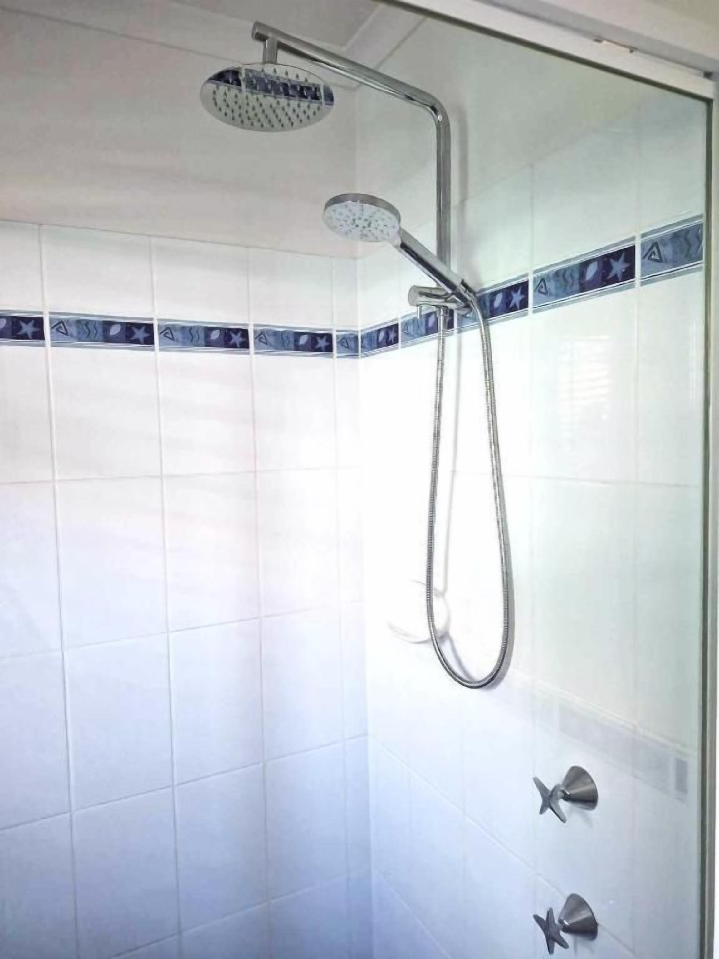 Ducha con cabezal de ducha de mano y grifo empotrado.