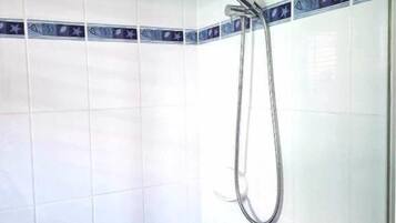 Ducha con cabezal de ducha de mano y grifo empotrado.