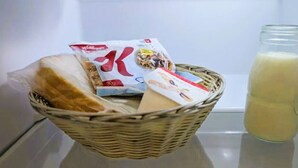 A wicker basket containing bread, a milk carton, and a cereal box on a kitchen counter. - Central Studio Accommodation (Gladstone)