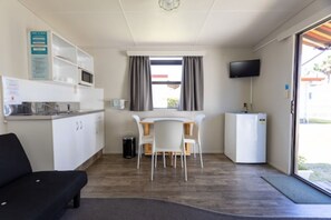 Kitchen Cabin (No Linen Supplied) | Living area | 22-inch flat-screen TV with satellite channels, TV, books