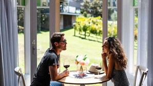 A couple dining at a table with a view of a garden and a house in the background. - Araluen Lodge Yarra Valley (Steels Creek)