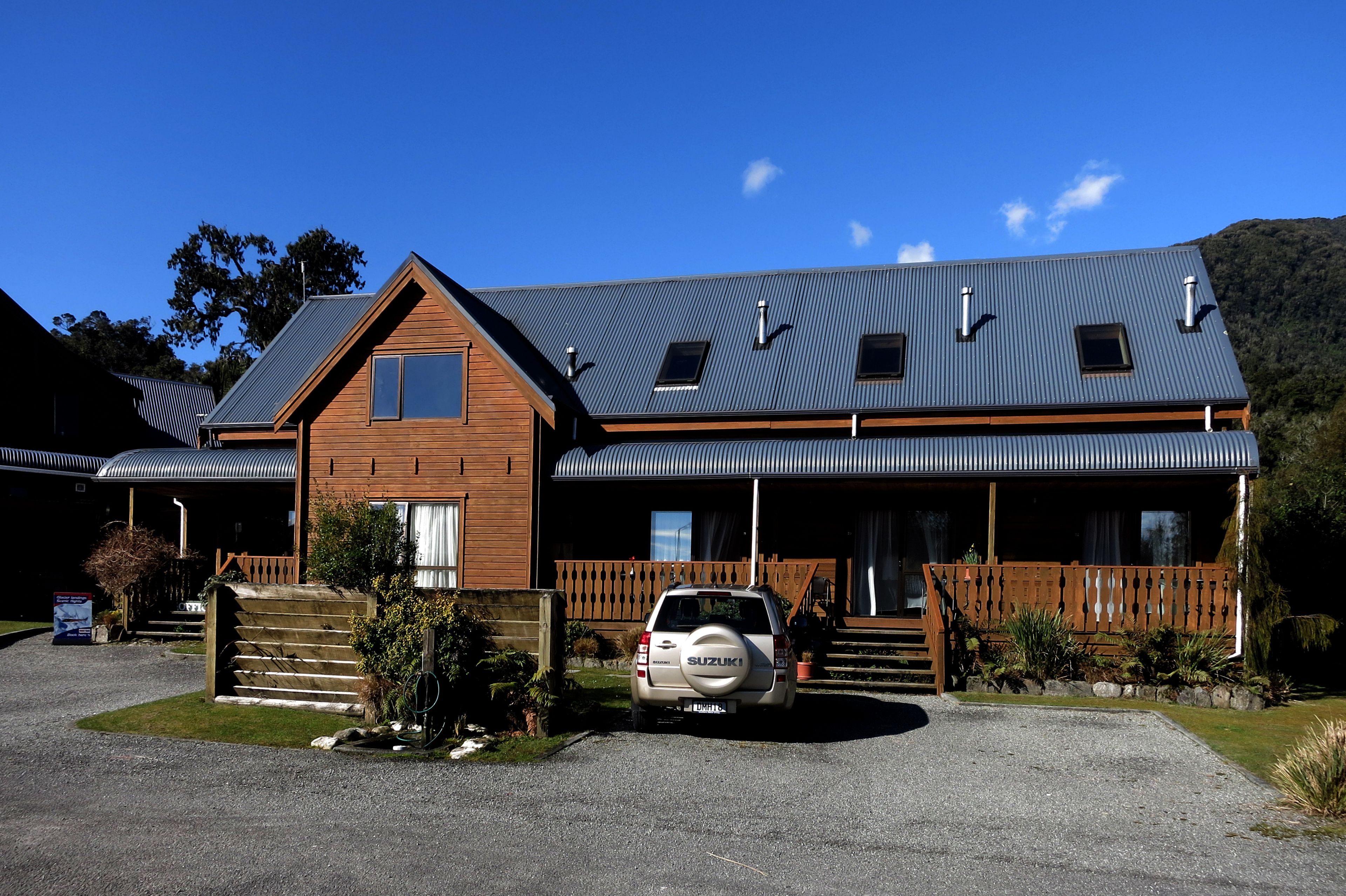 A two-story building with a wooden facade and a grey metal roof.