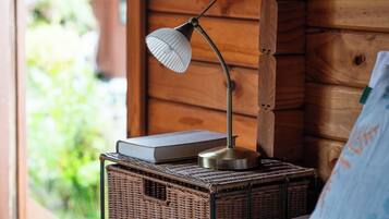 Ein Korbwäscher mit einer Lampe und einem Buch an einer Holzwand.