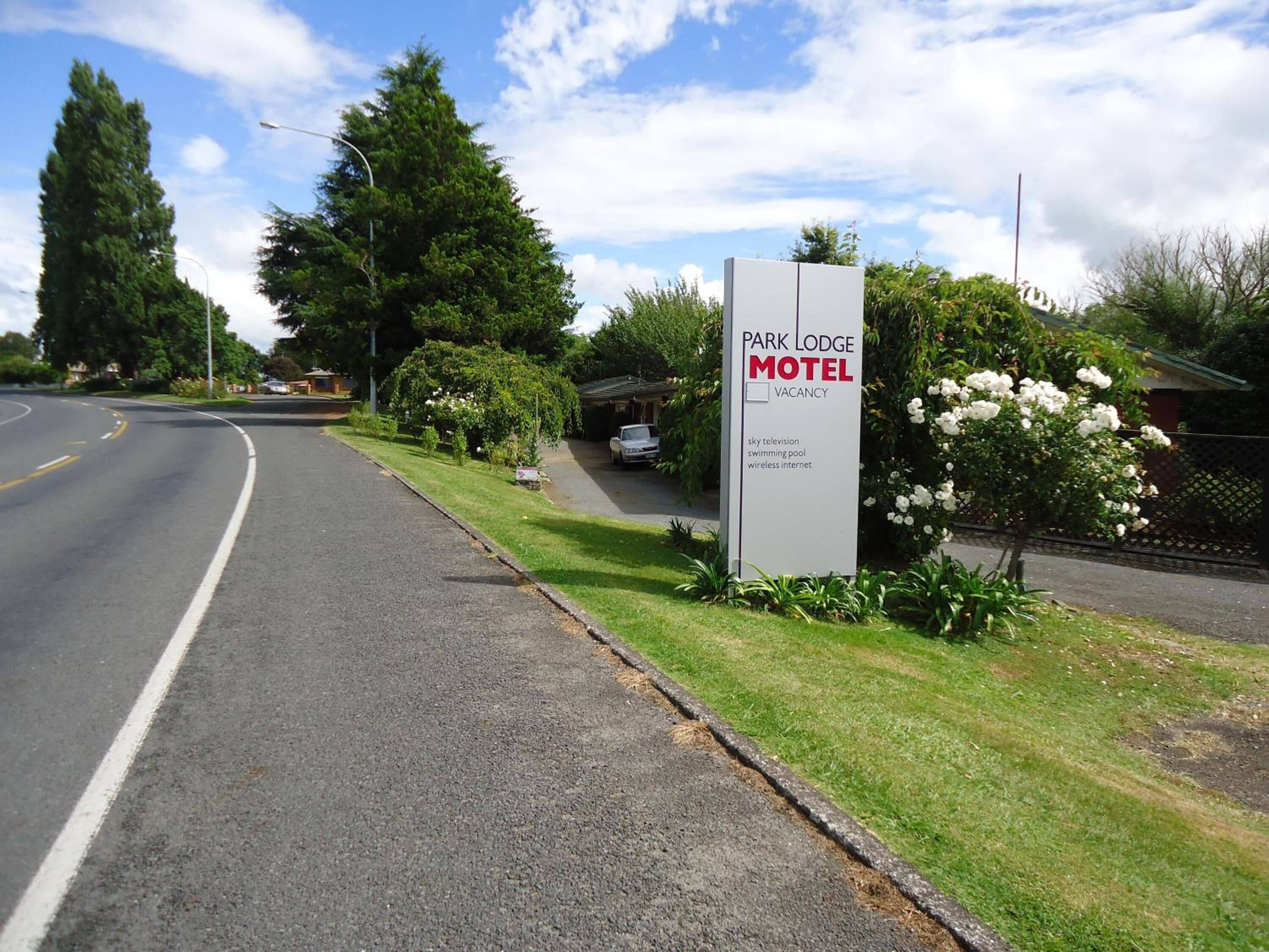 A sign for Park Lodge Motel with amenities listed including sky television, swimming pool, and wireless internet.