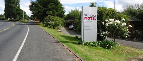 A sign for Park Lodge Motel with amenities listed including sky television, swimming pool, and wireless internet.