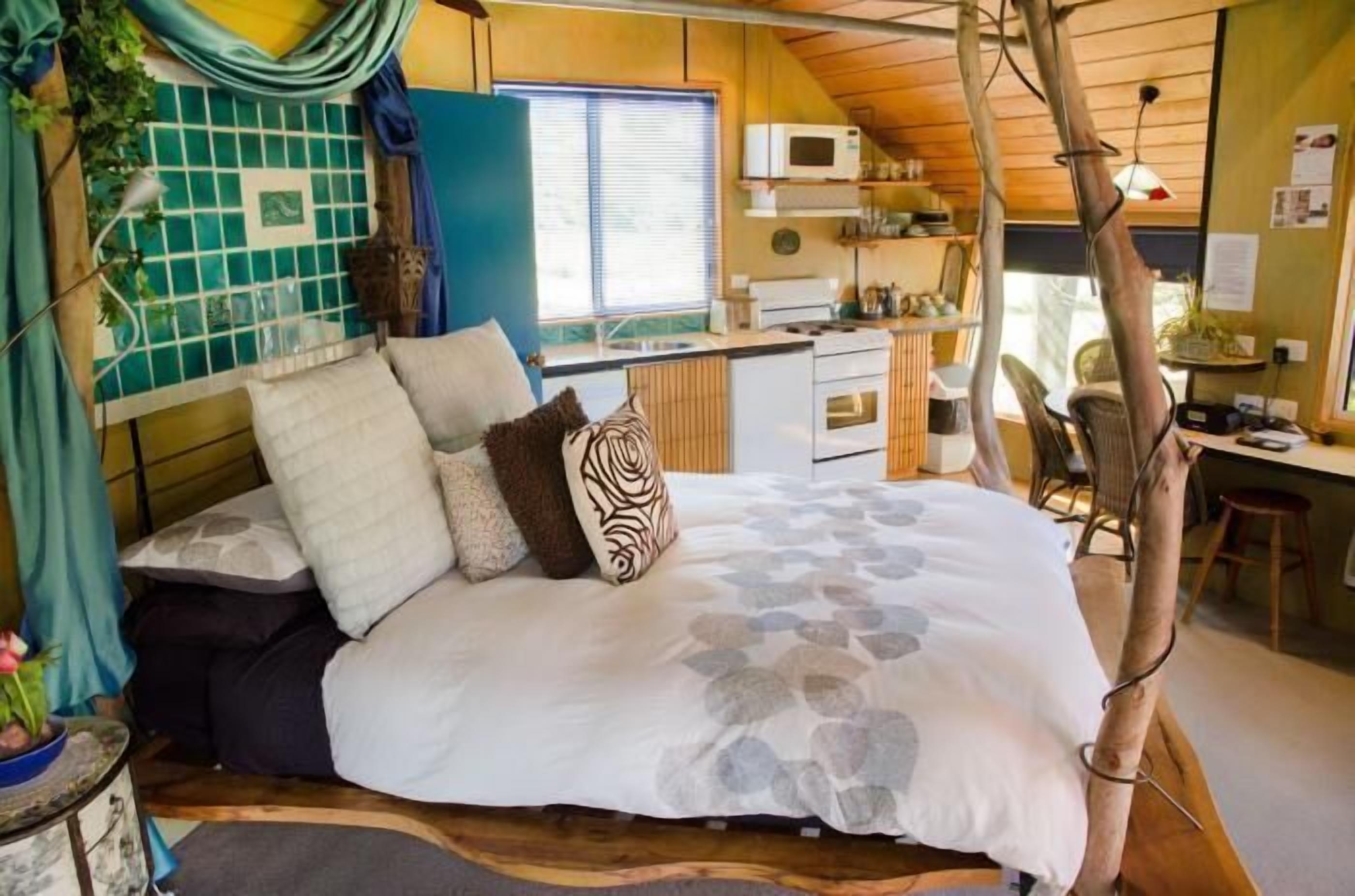 Een gezellig slaapkamer met een groot bed, een kleine kitchenette en een eethoek.