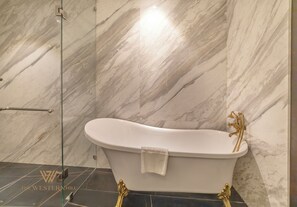 Bañera con ducha, artículos de tocador de diseñador, secador de pelo