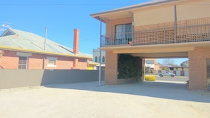A two-story building with a balcony on the upper floor, a brick facade, and a clear sky. - Holbrook Town Centre Motor Inn (Holbrook)