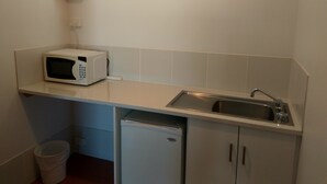 A compact kitchen with a microwave, sink, and a small refrigerator. - Holbrook Town Centre Motor Inn (Holbrook)
