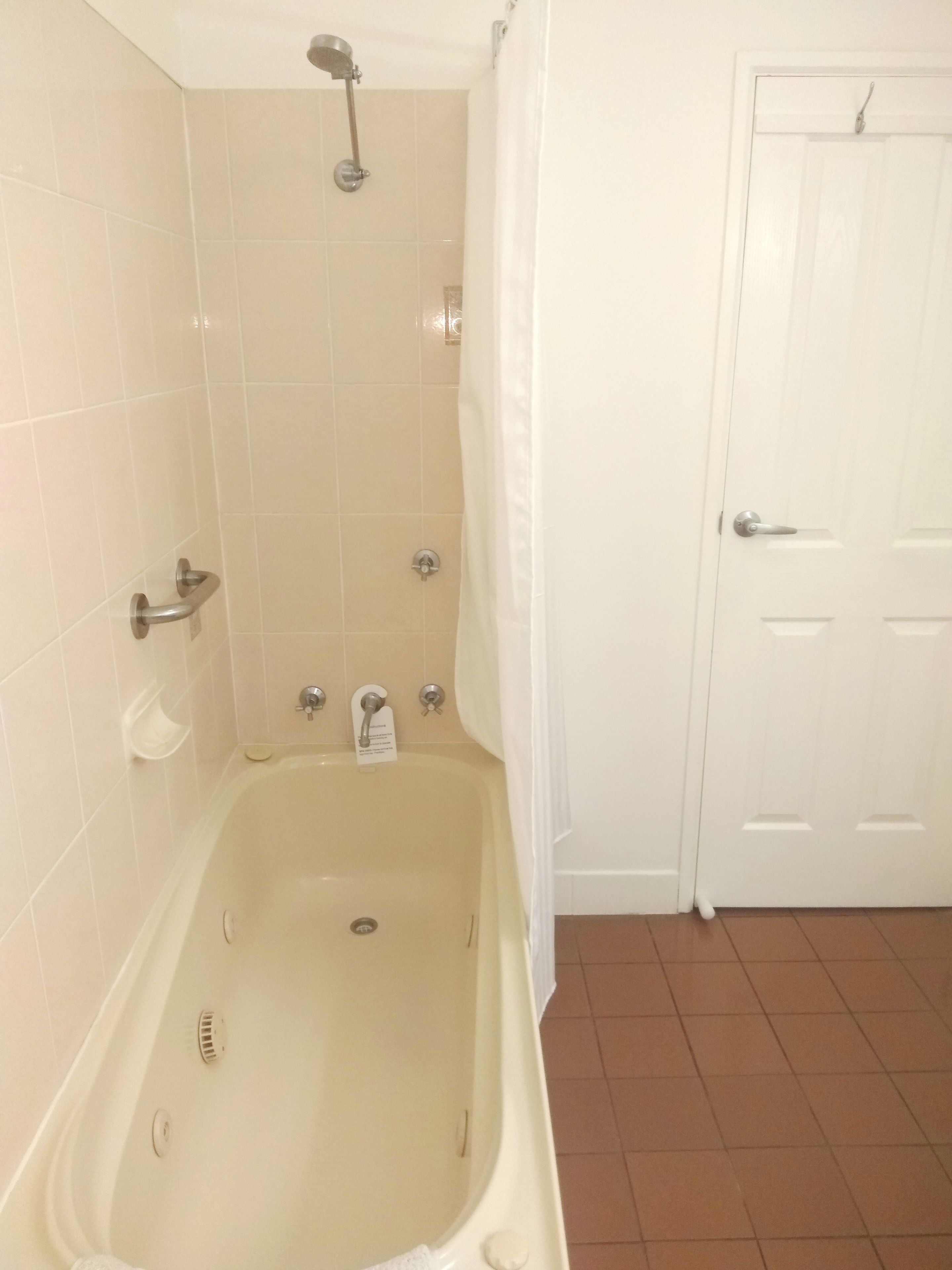 Un baño con bañera, ducha y retrete.