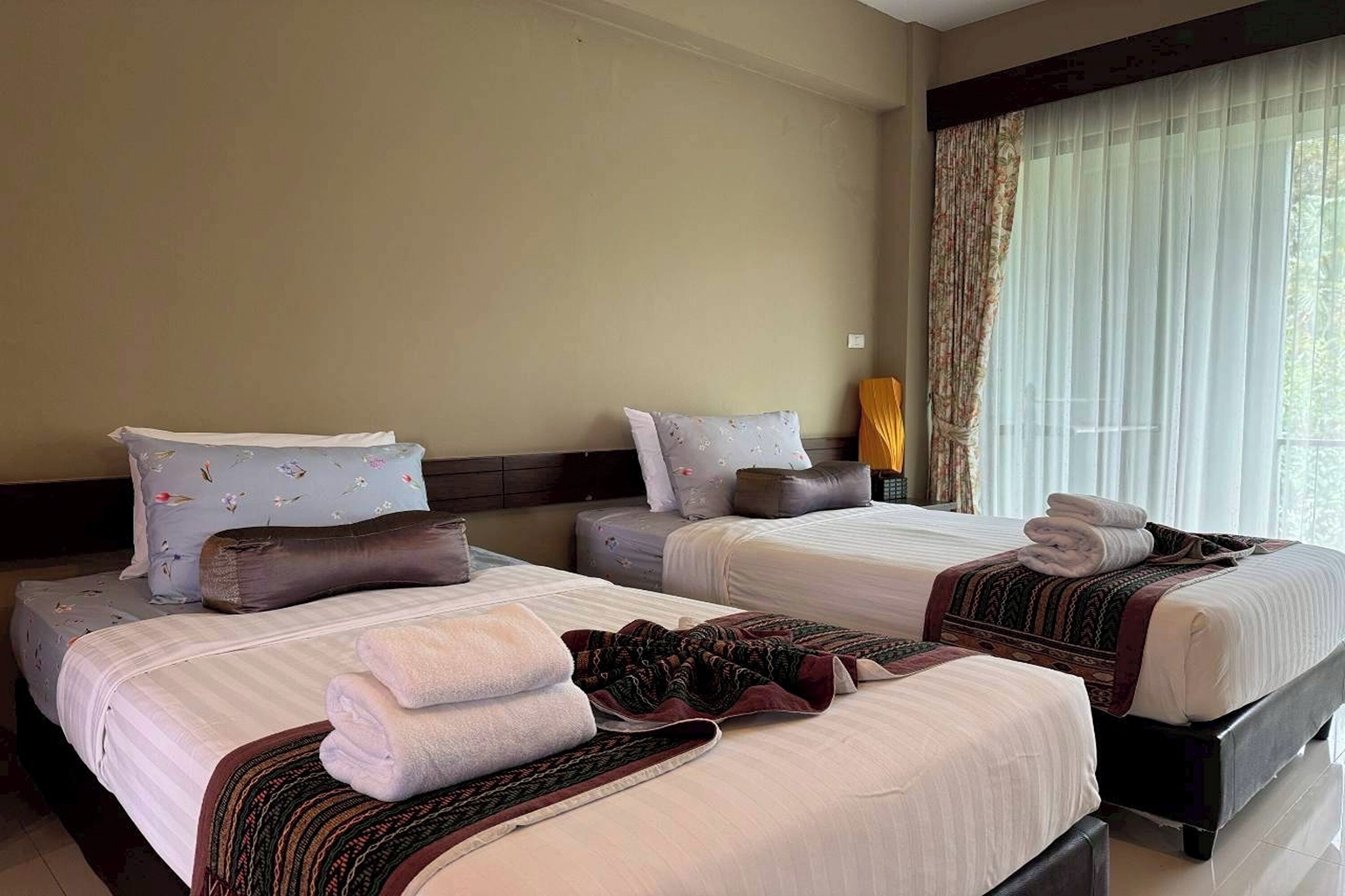 Une chambre d’hôtel avec deux lits, chacun étant équipé d’un oreiller et d’une couverture.
