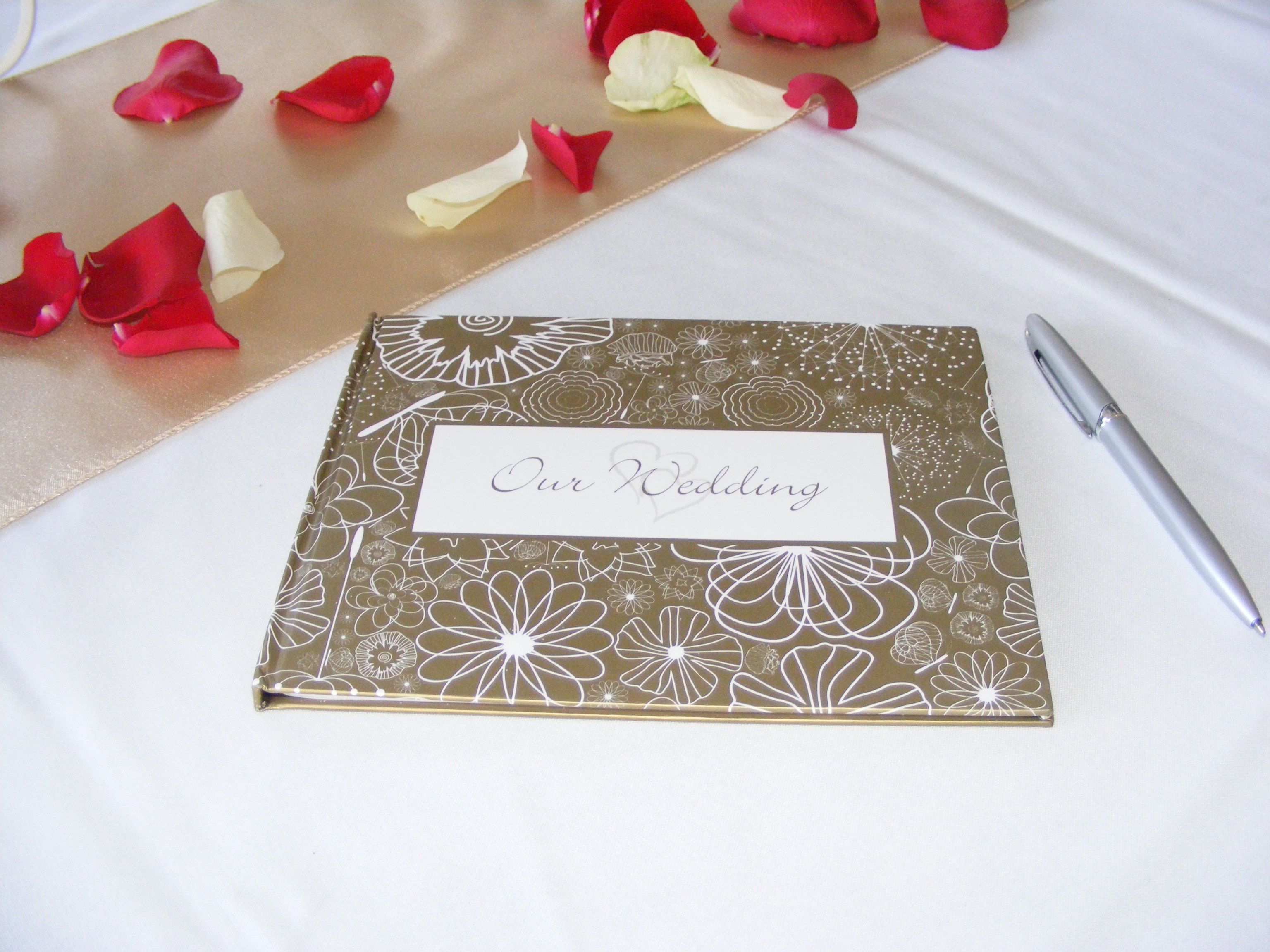 A notebook with a floral pattern and a label that reads "Our Wedding."