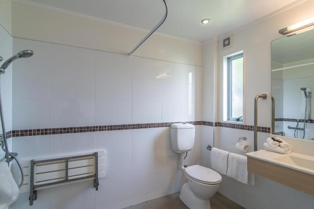 A modern bathroom with a toilet, bidet, and shower.