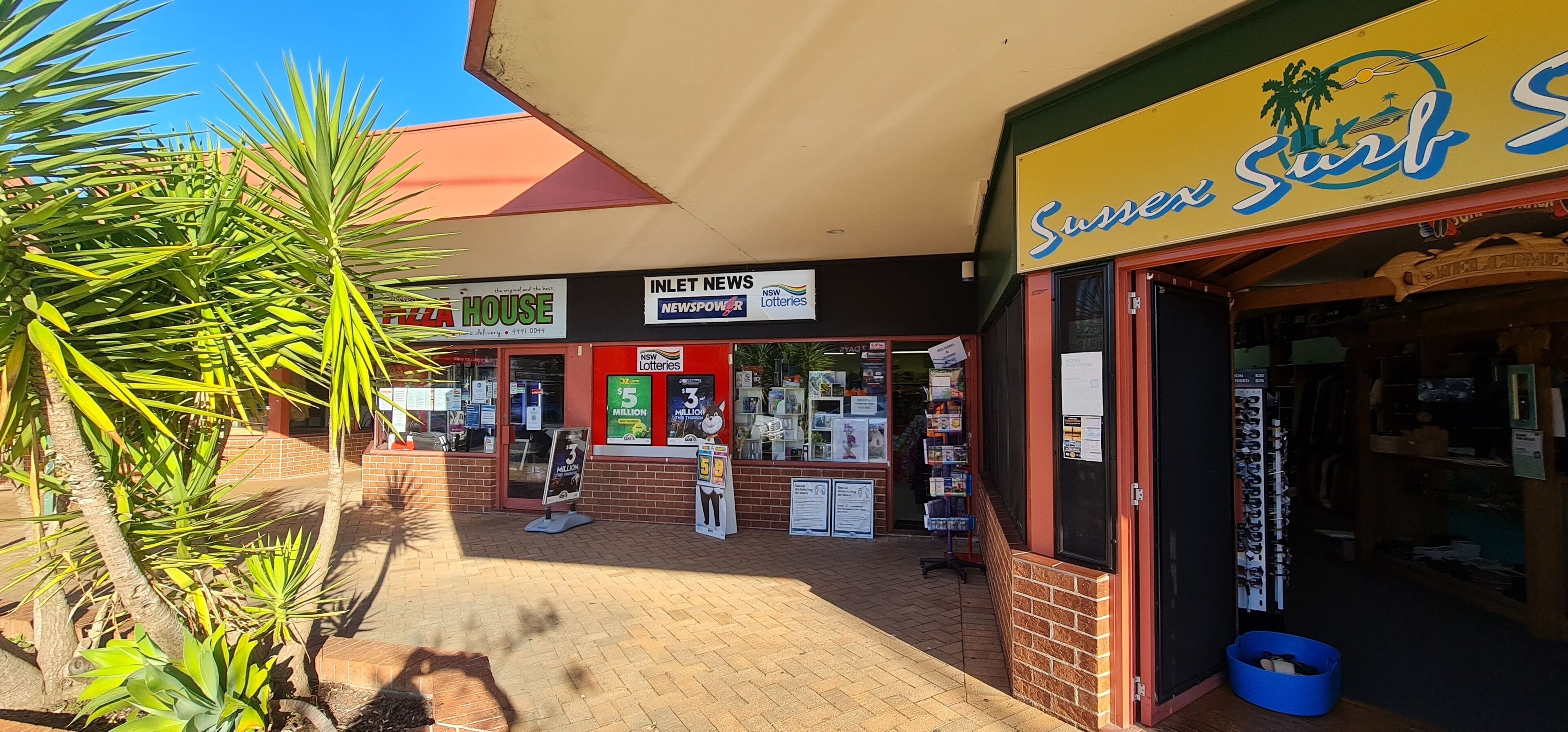 A storefront with a 'Sunshine Soul' sign, a 'House' sign, and a 'News' sign.
