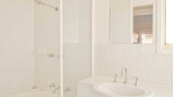 A bathroom with a bathtub, a sink, and a shower.