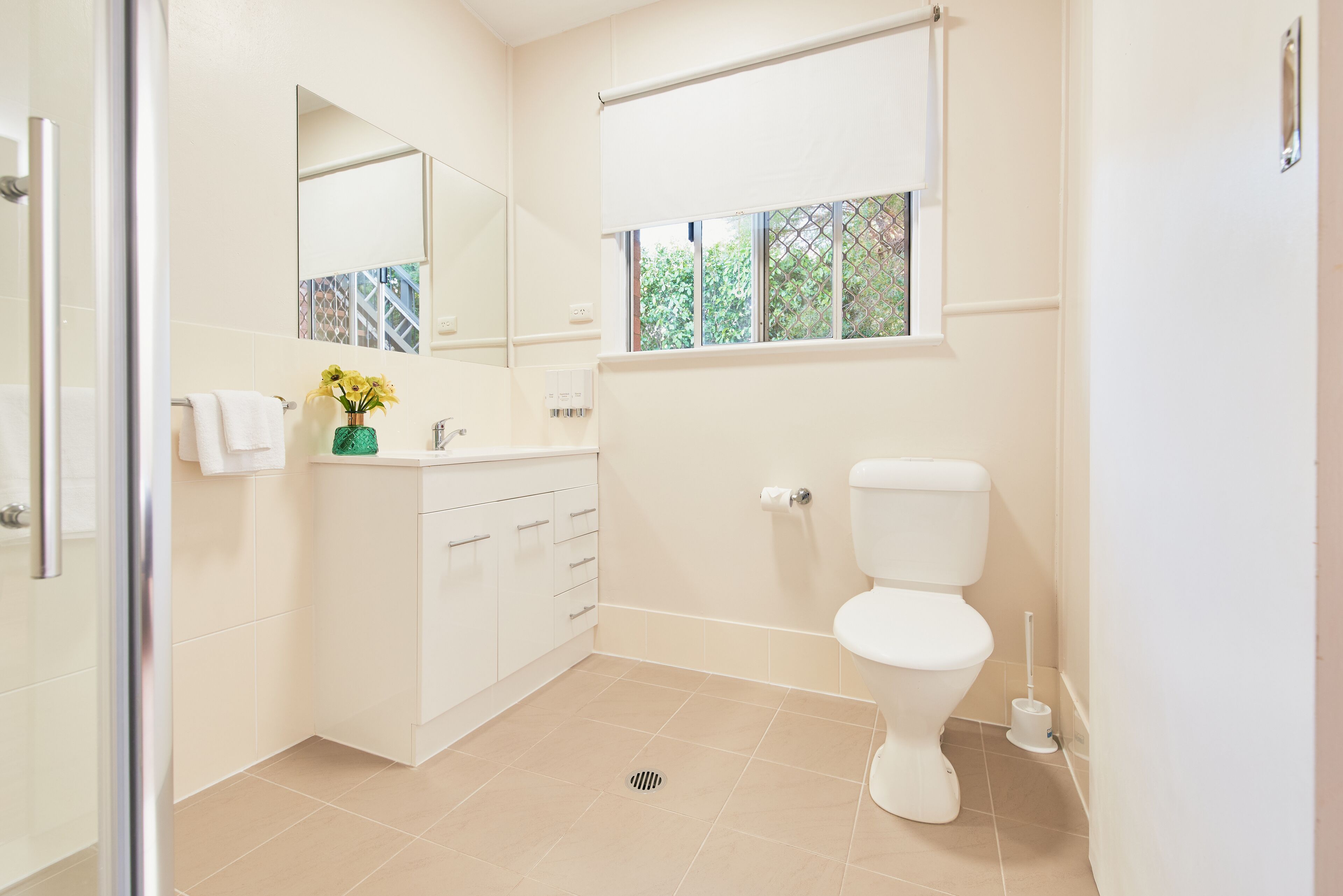 A modern bathroom with a toilet, sink, and mirror.