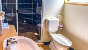 Un bagno con un lavandino bianco, un water e un box doccia in vetro.