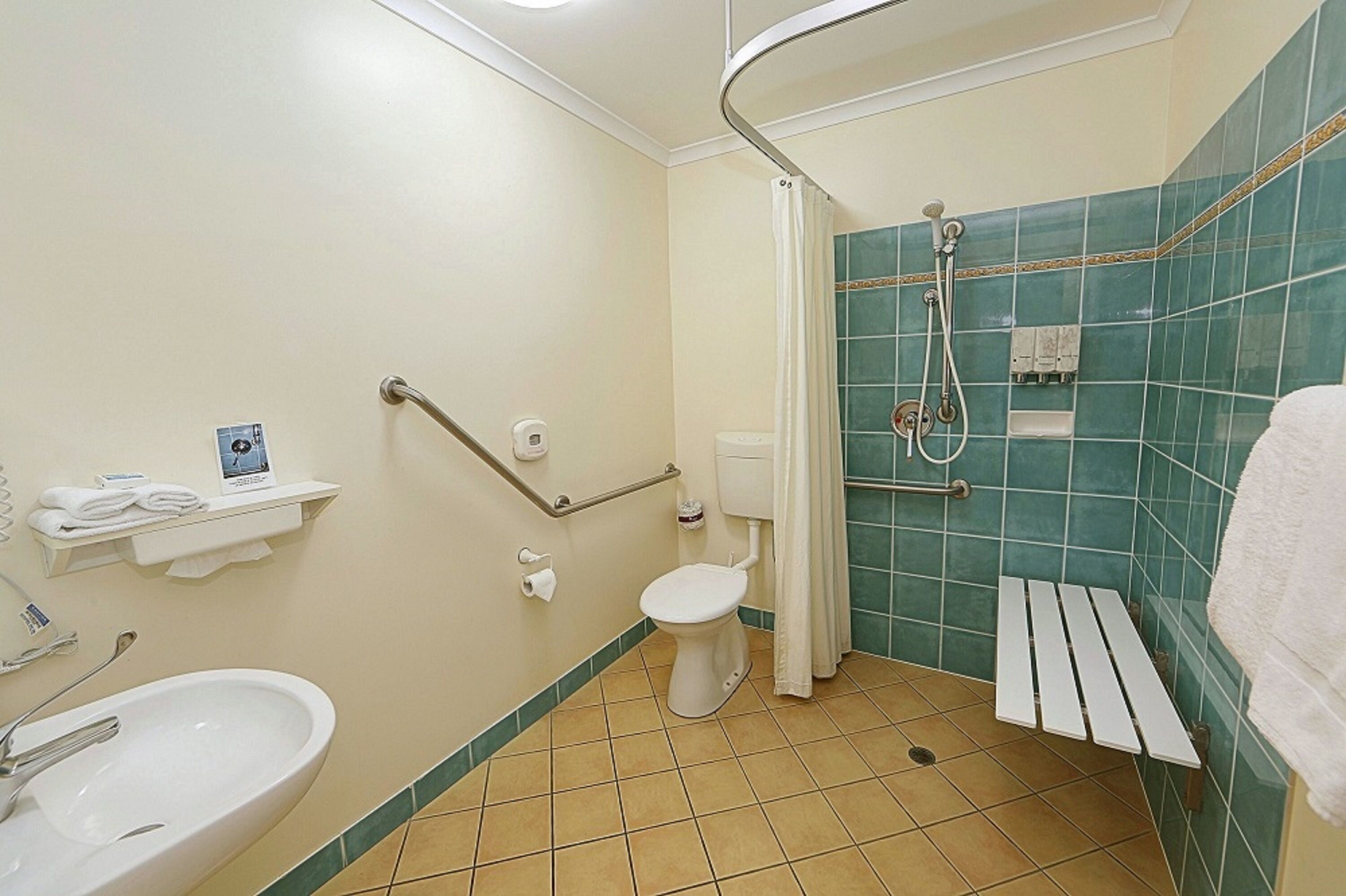 A bathroom with a toilet, sink, and shower.