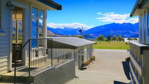 Um hotel com área externa coberta, vista para as montanhas e estacionamento.