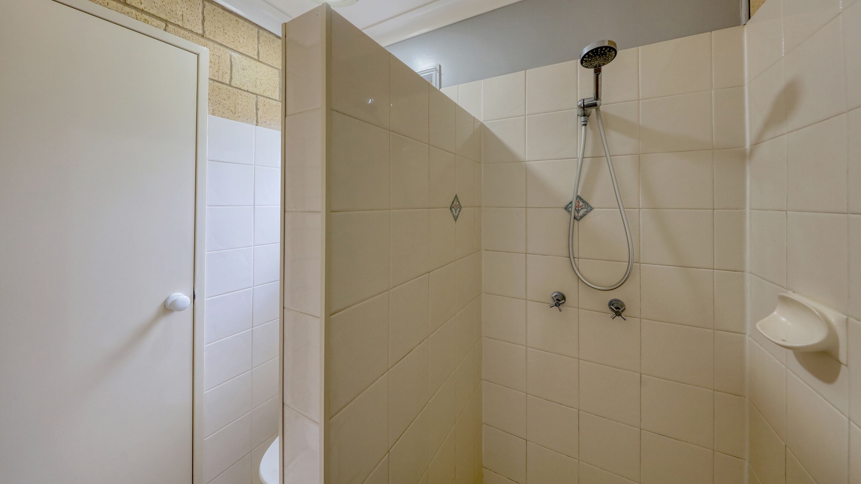 A bathroom with a shower, a toilet, and a sink.