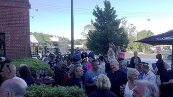 A group of people gathered outdoors, possibly at a social event or gathering.
