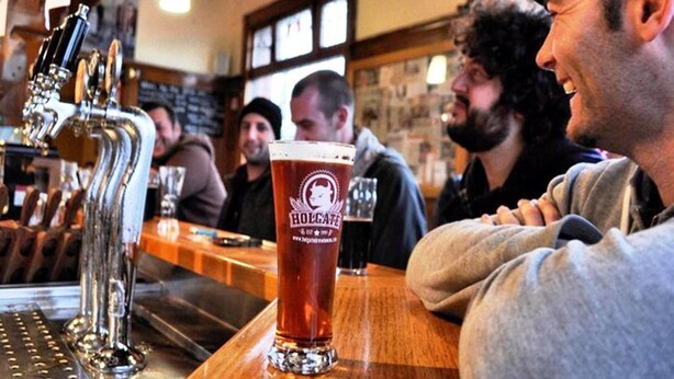 Een bar met een biertappunt en een glas bier.