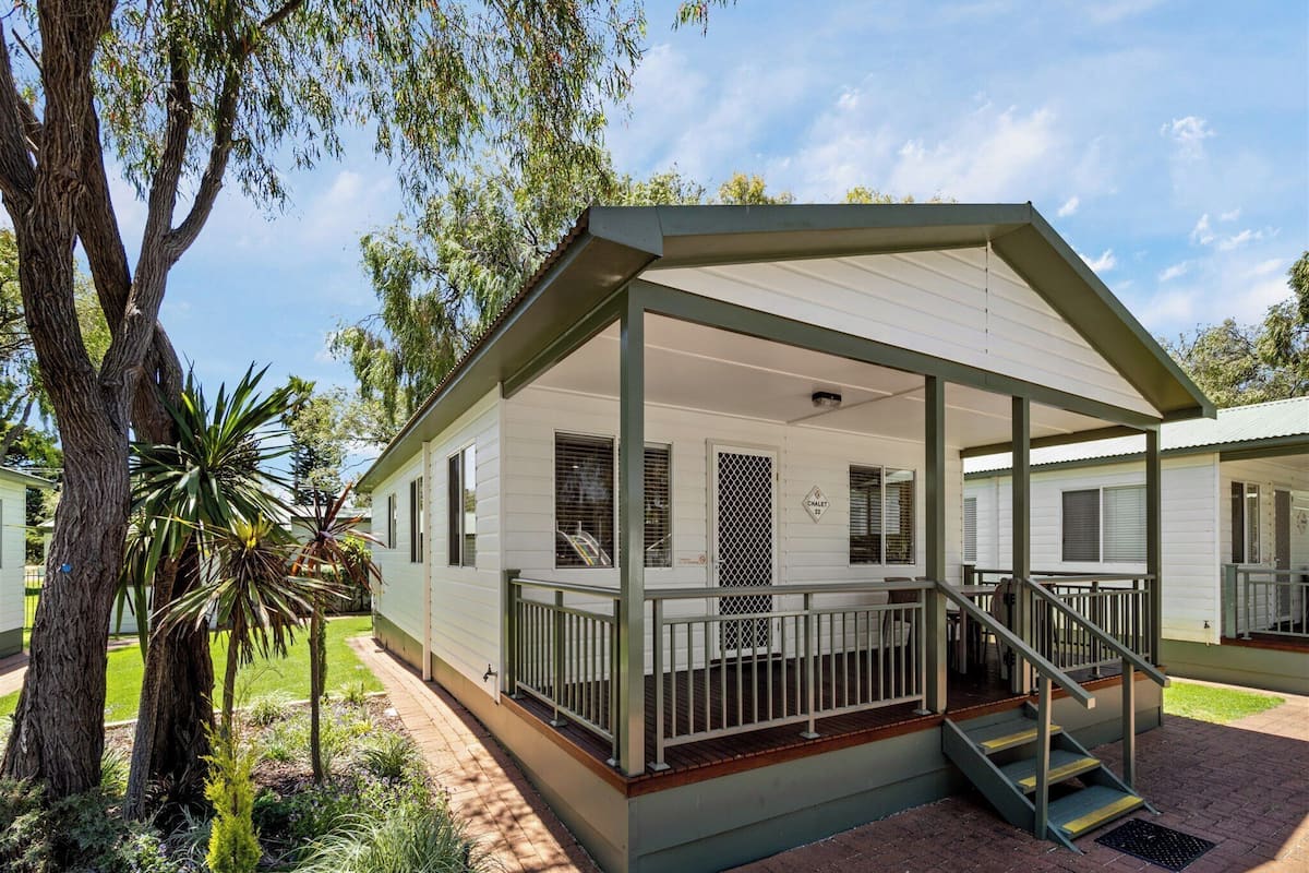 A single-story mobile home with a covered porch and a staircase leading to the entrance.