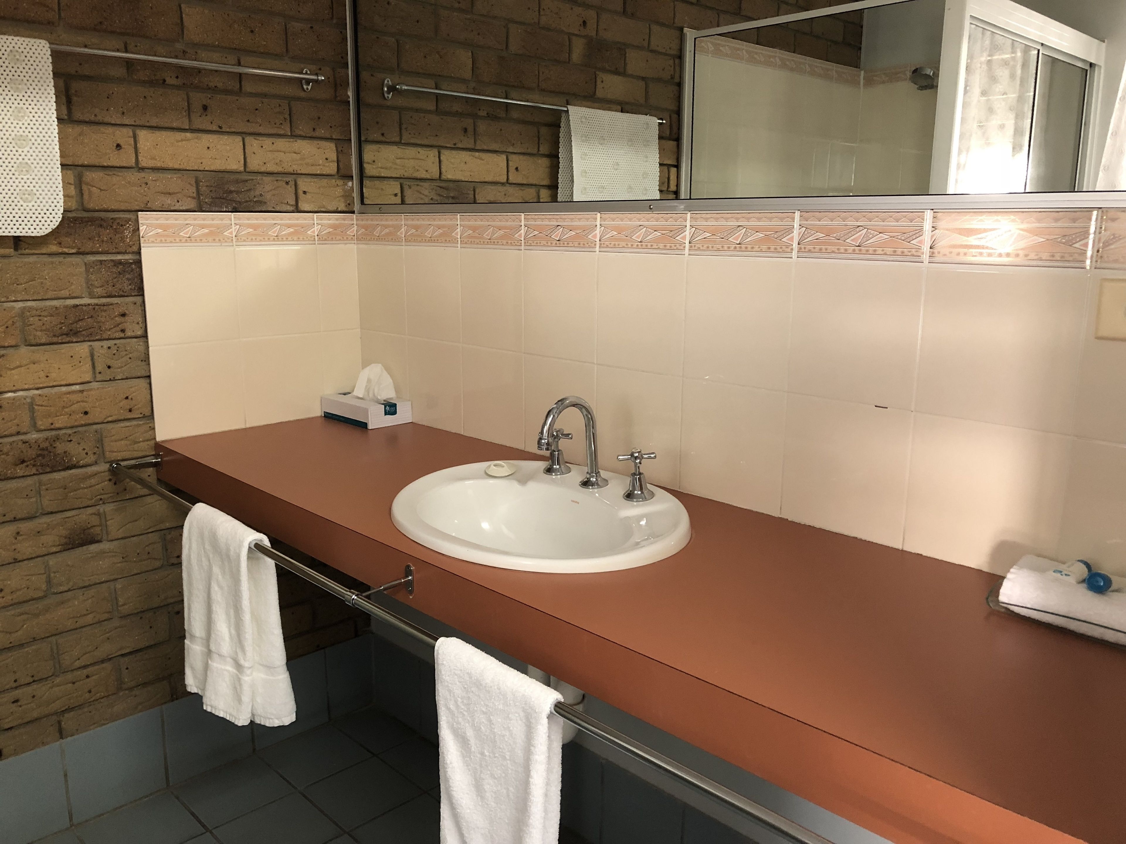 A bathroom with a sink, towel rack, and a mirror.