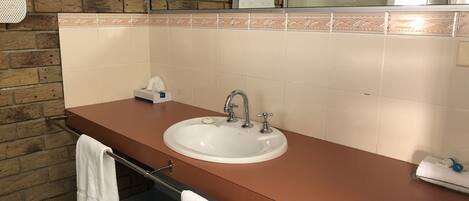 A bathroom with a sink, towel rack, and a mirror.